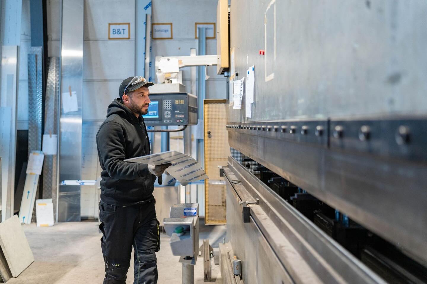 Ein Mitarbeiter arbeitet in der Werkstatt an der Abkantbank.