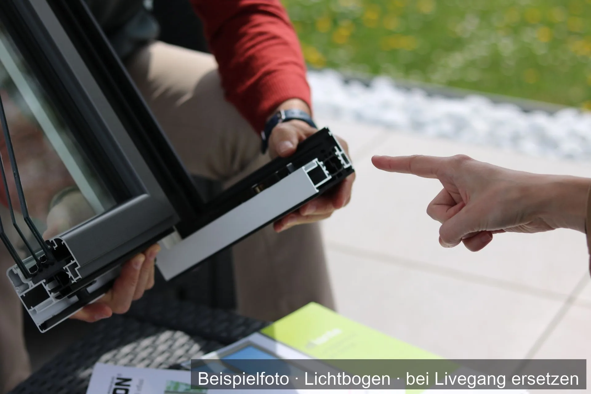 Ein Berater zeigt einer Kundin ein Aluminium-Fensterprofil.