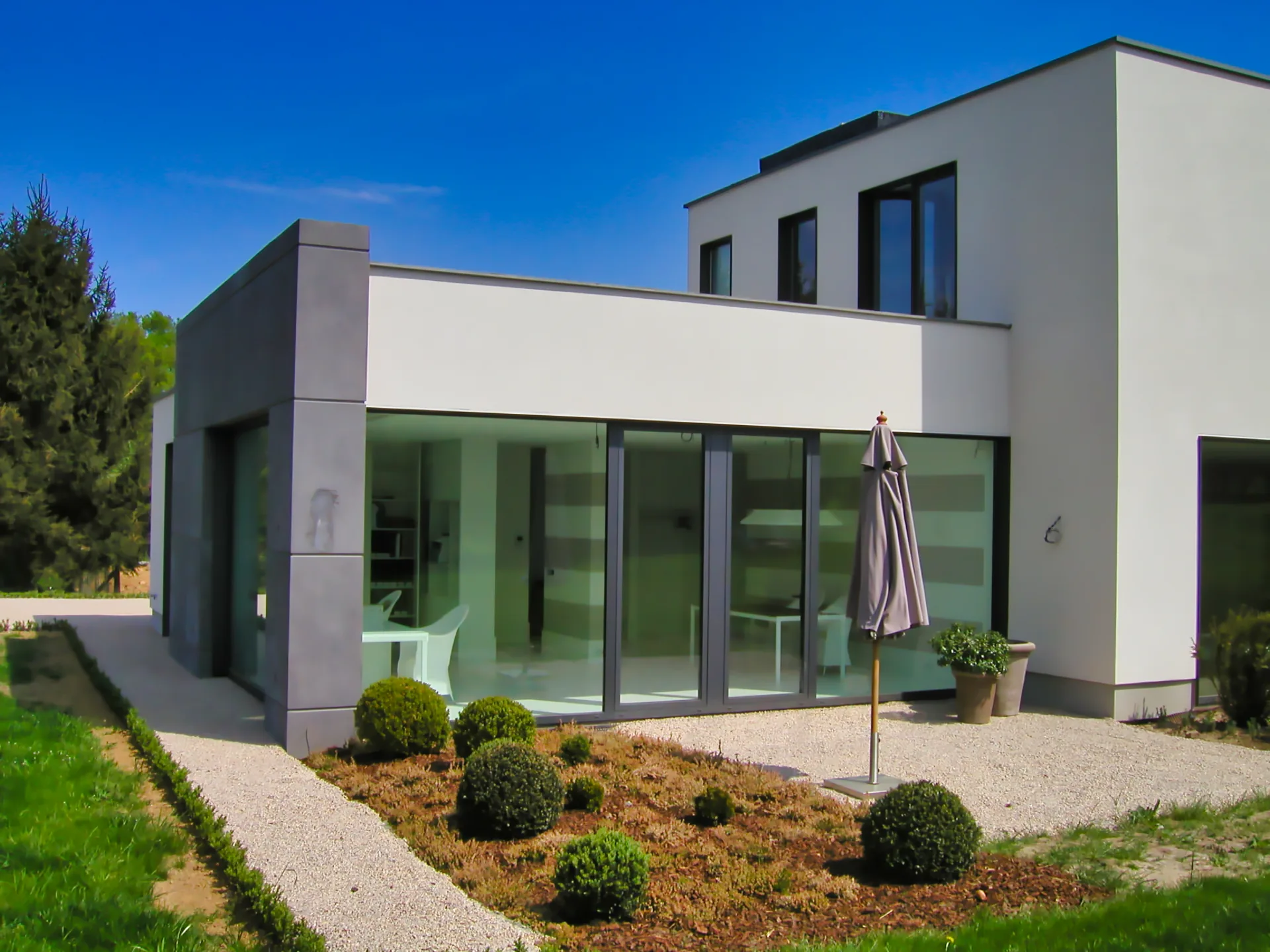 Kubusförmiges Wohnhaus mit großen Glasflächen.